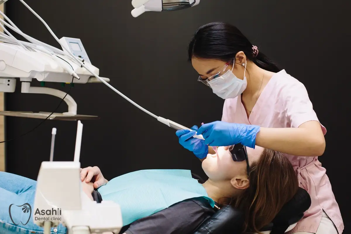 Nha sĩ cạo vôi và làm sạch răng cho bệnh nhân trên ghế nha