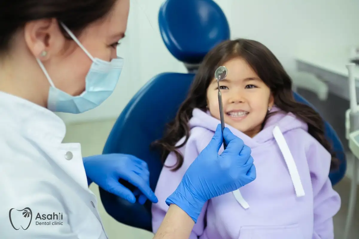 Nha sĩ cho bé làm quen với gương nha khoa để bé không còn sợ đi khám răng