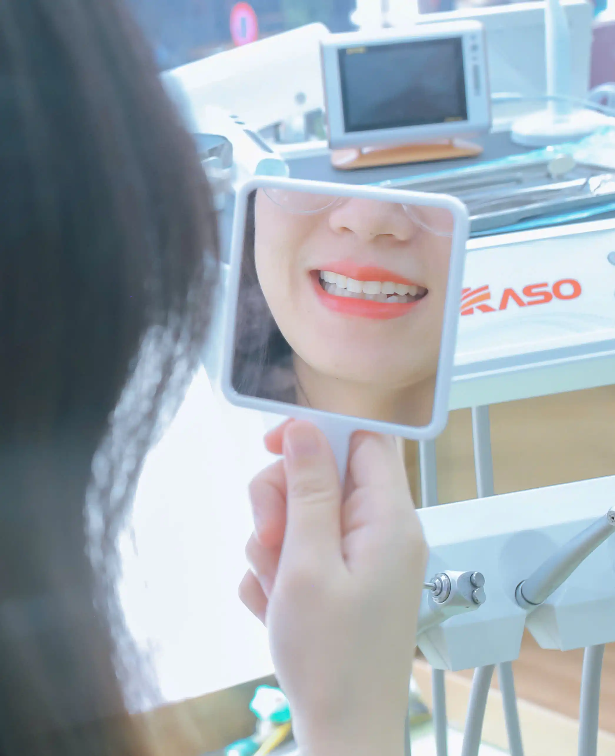 Khách hàng ngắm nụ cười của mình qua gương tại phòng khám Asahii