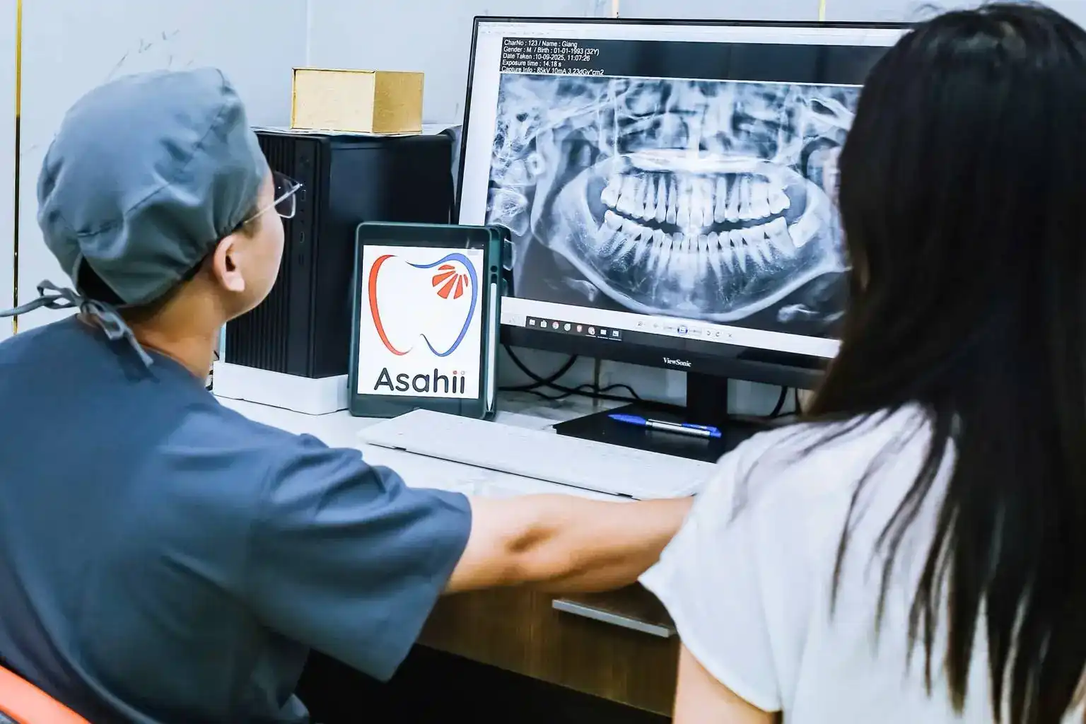 Bác sĩ Asahii giải thích phim X-quang cho khách hàng trên màn hình